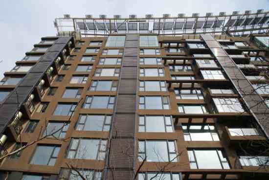 Solar façade integration at Utopia Garden Project: The domestic hot water tanks have been mounted to the outside of the balconies (left, in the picture) behind a wall with horizontal vacuum tubes. The tubes have been placed on top of each other through all 20 floors of the building.